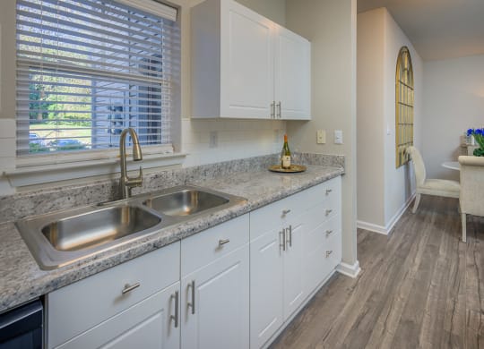 white kitchen cabinets and natural light filled kitchen with hardwood floors at Stone Ridge apartments Charlotte