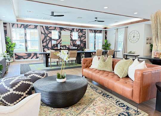 A living room with a brown leather couch and a round coffee table.