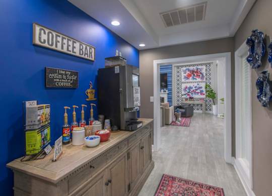 A coffee bar with a blue wall and a wooden counter.