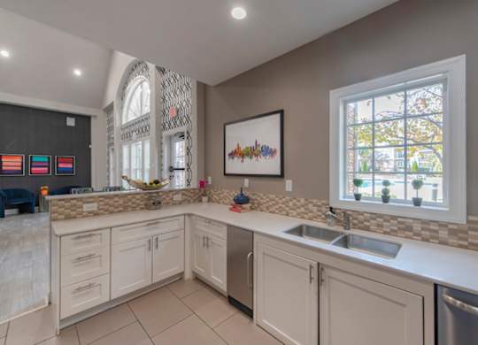 A kitchen with a large window and a sink.