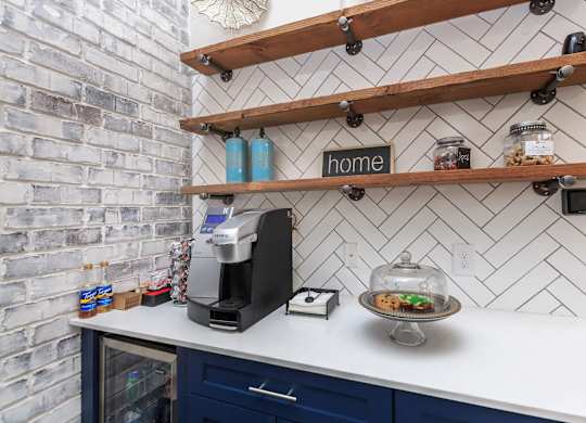A kitchen counter with a coffee maker and a plate of cookies.