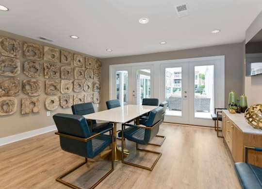 a modern room with a table and chairs and a television on the wall at Canopy apartments in South Charlotte