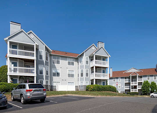 a large apartment complex with cars parked in front of it