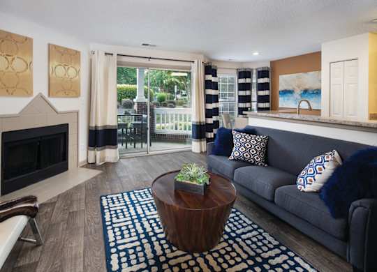 A living room with a fireplace and a blue couch.