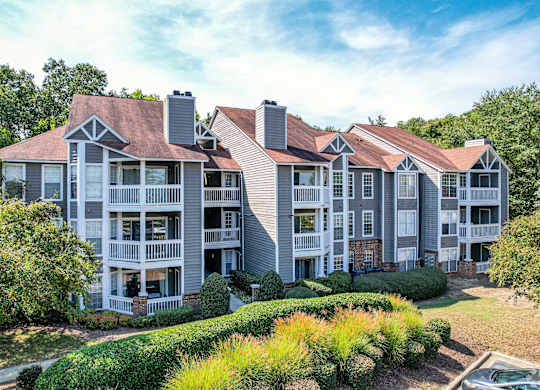A large apartment complex with multiple balconies and a mix of brick and siding exteriors.