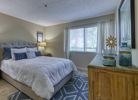 One Bedroom Apartments in Vinings, GA - Wynnwood Vinings - Furnished Bedroom with Plush Carpet Flooring and a Window