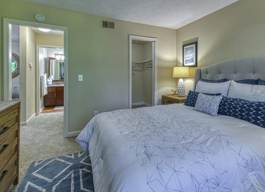 a bedroom with a large bed and a bathroom in the background at Wynnwood Vinings