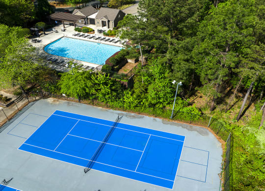 Vinings, GA Pet-Friendly Apartments - Wynnwood Vinings - Pool Area with Lounge Chairs and Two Tennis Courts, Surrounded by Beautiful Landscaping