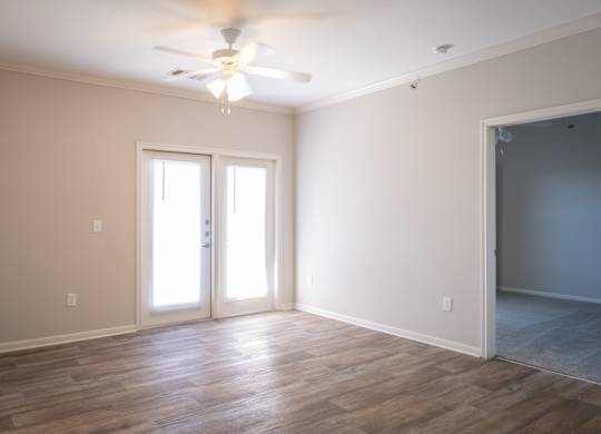 A room with a ceiling fan and two doors.