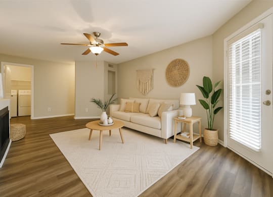 A living room with a white couch and a wooden coffee table.
