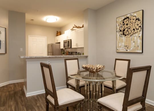 A dining room with a glass table and chairs.