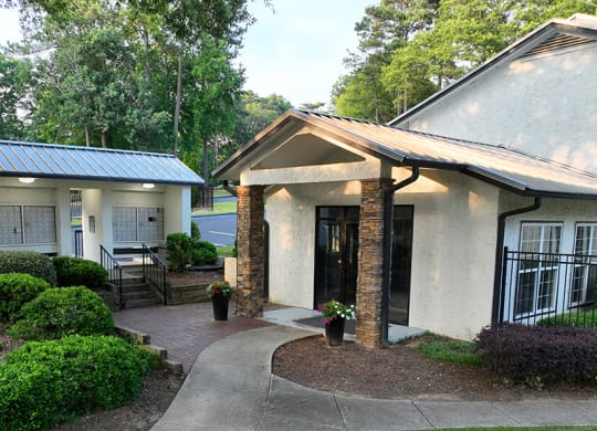 a small white building with a walkway in front of it