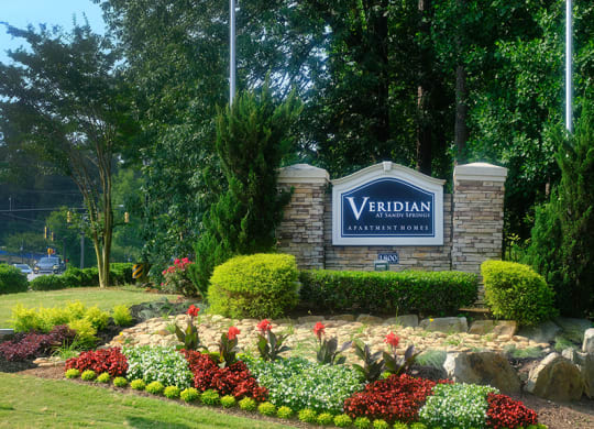 a garden with flowers and rocks in front of a yarddan sign