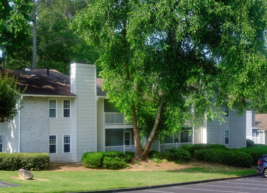 a picture of an apartment building with a large tree in front of it