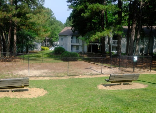 a park with two benches and a fence
