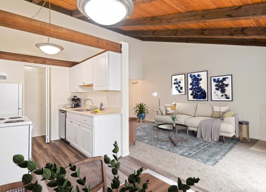 A living room with carpet floors and view into dining room and kitchen at Foster Creek apartments in Tukwila, WA