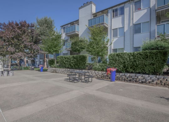 An open area outside of Foster Creek apartment homes with tables and space for outdoor lounging