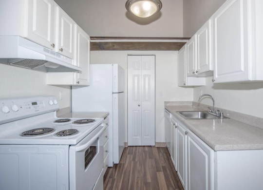 Renovated kitchen with white cabinets and all white appliances at Foster Creek apartments