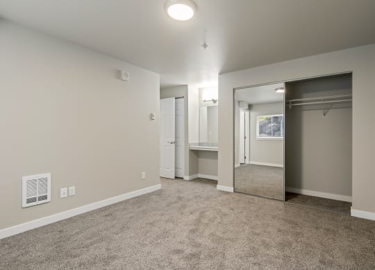 One-Bedroom Apartments in Tukwila, WA - Foster Creek - Unfurnished Bedroom with Carpet, Mirrored Closet, and Built-In Vanity with Mirror
