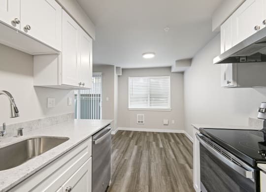 a kitchen with a sink and a stove and a window