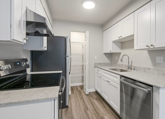 Apartments For Rent In Tukwila, WA - Foster Creek - Kitchen With A Pantry, White Cabinets, Hardwood Floors, And Refrigerator Dishwasher ,