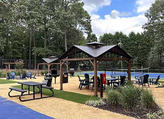 a picnic area with a pavilion next to a swimming pool