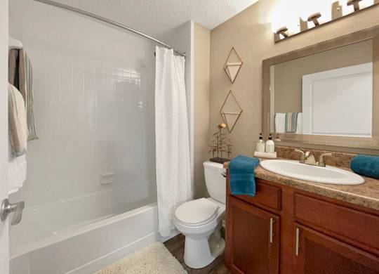 A bathroom with a toilet, sink, and shower.