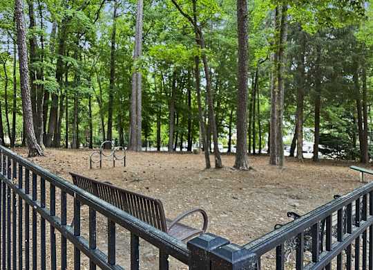 a park with benches and trees and a fence