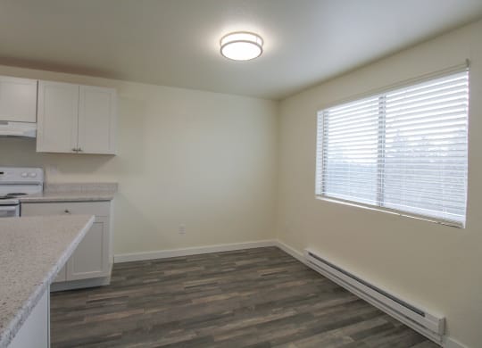 1-Bedroom Apartments in Tacoma, WA - Valley Vista - Dining Area by the Kitchen with an Overhead Light, Wood-Style Flooring, and a Window