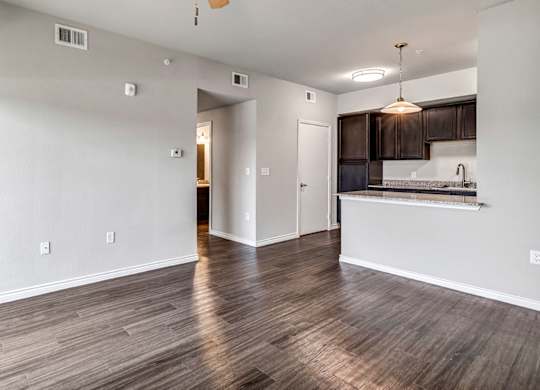 the living room and kitchen of an empty apartment