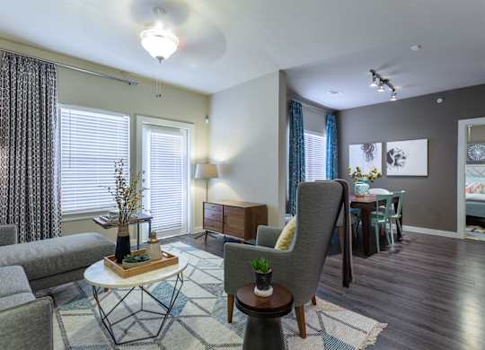 A living room with a grey couch, a white coffee table, and a grey armchair.