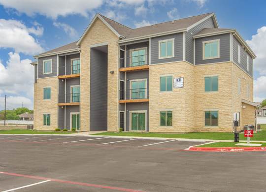 Exterior of Sendero Ridge Apartments with an empty parking lot