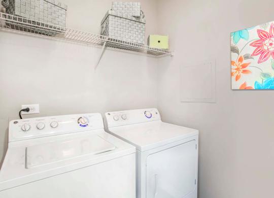 the washer dryer closet inside of an apartment at Seasons at Umstead apartments in Raleigh