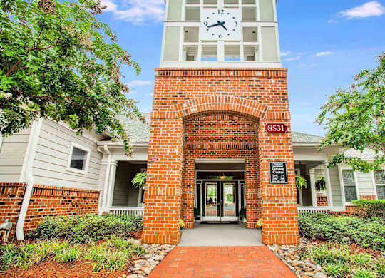 Entrance to leasing center at Seasons at Umstead apartments in Raleigh with clock tower and brick walls