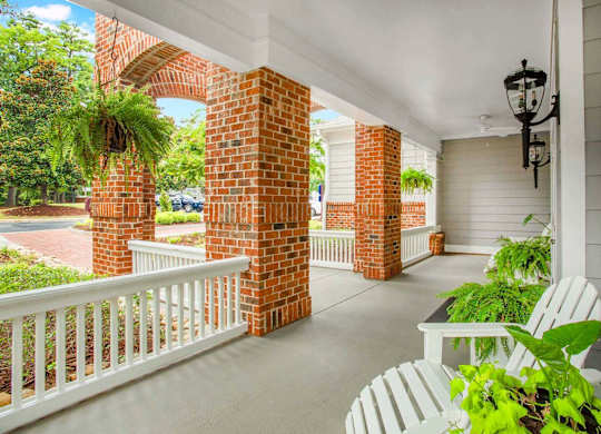 an inviting front porch with rocking chairs at Seasons at Umstead apartments in Raleigh