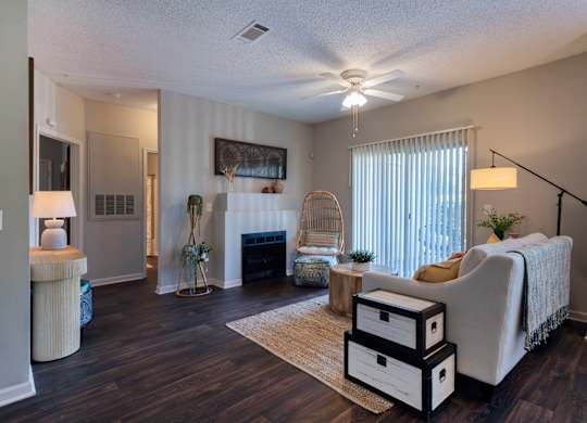 a living room at Seasons at Umstead apartments in Raleigh with a fireplace and a ceiling fan