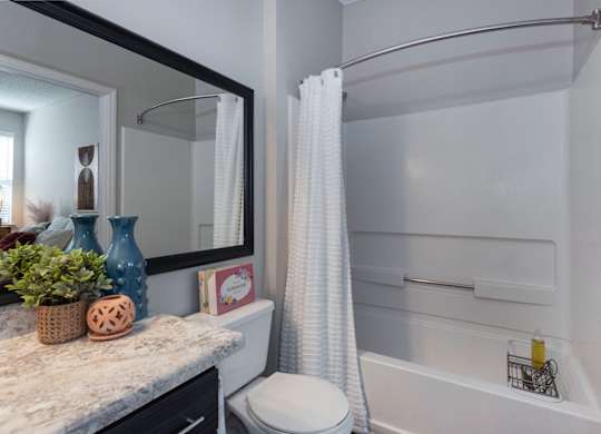 a bathroom with gray walls and a white shower curtain