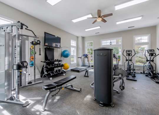 A spacious home gym with a variety of equipment including a treadmill, stationary bike, and weight machines.
