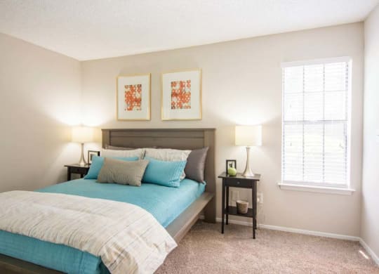 a bedroom with a bed and two lamps and a window