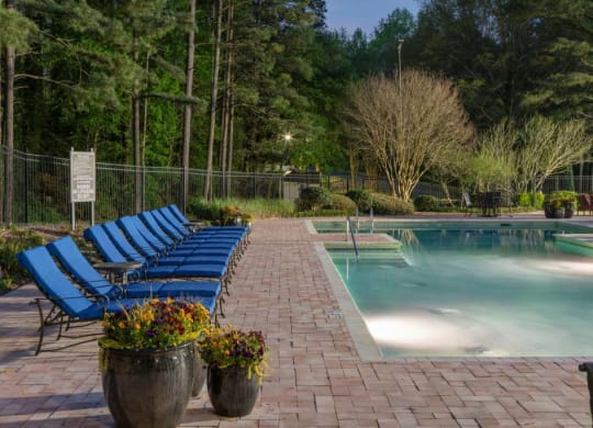 Veridian at Sandy Springs apartments resort pool with blue lounge chairs and potted plants