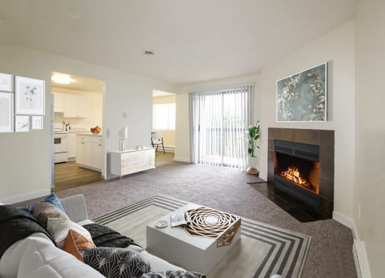 Stadium District, Tacoma, WA Apartments - Valley Vista - Living Room with Carpet Flooring, a Fireplace, a Couch, a Coffee Table, Stylish Decor, and a Sliding Glass Door to a Private Balcony/Patio