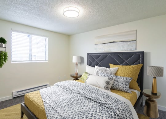 2-Bedroom Apartments in Tacoma, WA - Valley Vista - Bedroom with Carpet Flooring, a Bed, Nightstands, Lamps, and a Window