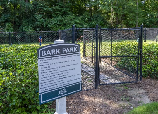 a sign for Wynnwood Vinings bark park in front of a fence