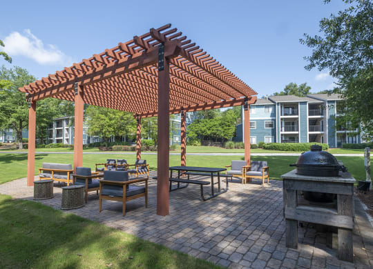 a group of tables and chairs in an outdoor picnic BBQ area at Wynnwood Vinings apartments