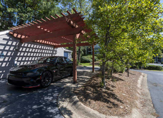 a car parked in a Car Wash amenity at Wynnwood Vinings apartments under a wooden shade