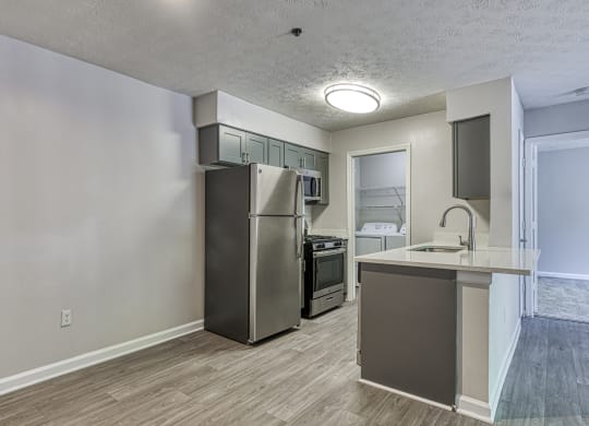 an empty kitchen with a stainless steel refrigerator and a counter top