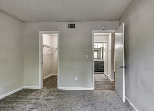 an empty bedroom in an apartment with a door to the walk in closet at Wynnwood Vinings