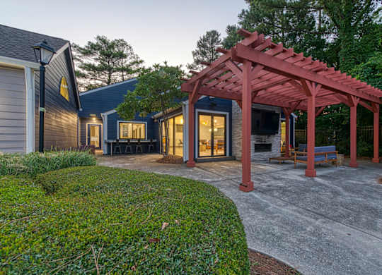 A house with a red pergola and a grey driveway.