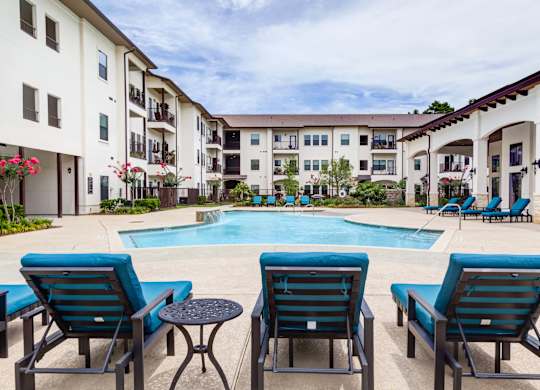 Pool along with chairs at The Laurel at Vintage Park 55+ Apartments, Tomball, 77377