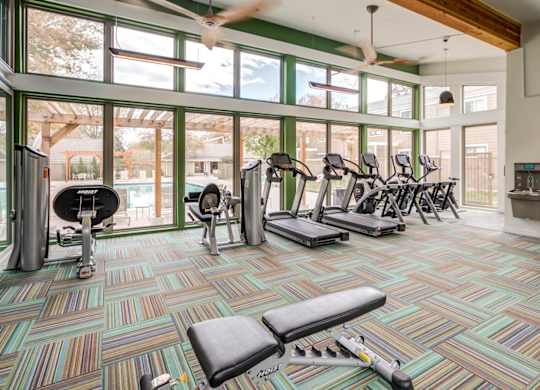 A gym with a variety of equipment including treadmills, weights, and exercise bikes at The Ranch at Bear Creek Apartments, Colorado, 80227